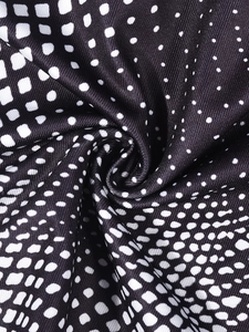Détail de la texture du tissu à pois noirs et blancs avec une finition tissée soyeuse