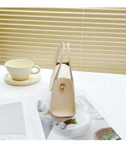 Detail view of beige lychee texture leather mini handbag with top handle and metal D-ring