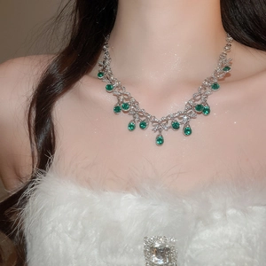 Close-up of elegant emerald water-drop pendant necklace with sparkling diamonds