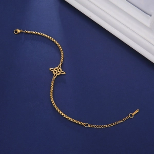 Macro shot of gold stainless steel box chain bracelet featuring a hollow cross knot pendant