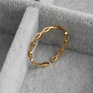 Macro shot of gold infinity link open ring placed inside a gray velvet jewelry gift box