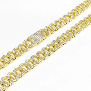 Detail shot of a 12.5mm gold-plated iced-out Cuban chain with diamond-set spring clasp