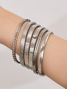 Détail de bracelets en acier inoxydable argenté avec zircon sur le poignet d'un mannequin