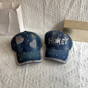 Detailed view of dark blue denim baseball cap featuring sparkly rhinestone heart pattern