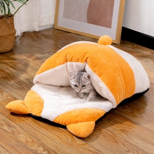 Detail view of the plush orange and white semi-enclosed pet bed on warm wood flooring