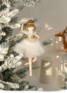 Close-up of ballet angel ornament with white mesh skirt and golden sequins on a tree