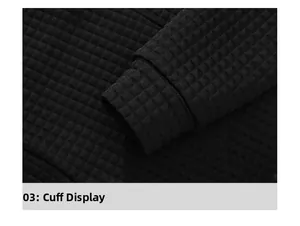Macro shot of black waffle knit texture and ribbed cuff detail on men's hoodie