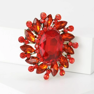 Detail of red crystal floral brooch with large oval gemstone on white pedestal