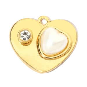 Detailed view of a gold heart pendant with a white pearl inlay and sparkling crystal