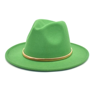 Detail of green wool fedora hat with gold ribbon trim and classic pinched crown