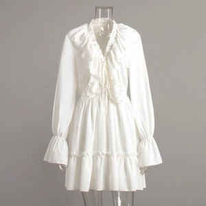 Detail of white V-neck dress featuring tiered ruffles and bell sleeves for a romantic look