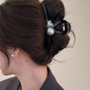 Detail of hair claw clip with grey imitation pearl and heart-shaped rhinestone decoration