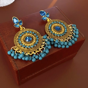 Detailed close-up of vintage gold earrings with blue crystals and bead tassels