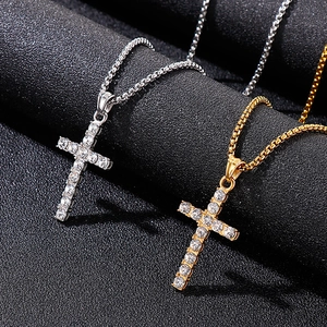 Gros plan de pendentifs croix en or et argent sertis de faux diamants sur fond noir
