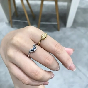 Close-up of celestial sun and moon rings set with sparkling crystals worn on hand