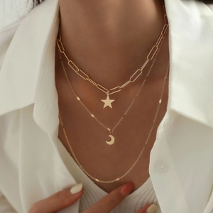 Three-layer gold necklace with paperclip chain, star and crescent moon pendants on model