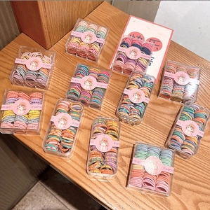 Close-up of colorful high-elastic hair ties in acrylic boxes with cute girl illustrations