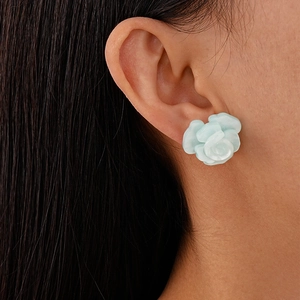 Macro view of light blue resin rose stud earrings on model showing realistic size and petal detail