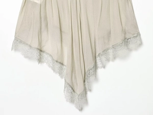Detail of champagne satin garment featuring delicate eyelash lace trim and silky texture