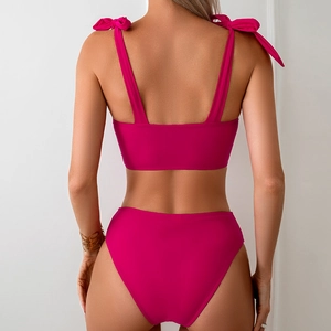 Detail of rose red high-waisted bikini set with decorative shoulder ribbon bows on back