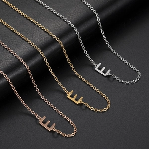 Detailed view of Letter E necklaces in silver, gold, and rose gold stainless steel finishes