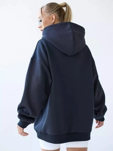Back view of a loose navy blue hooded sweatshirt with drop shoulder and ribbed cuffs