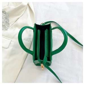 Vue de dessus de l'intérieur du sac matelassé vert avec poche zippée et bandoulière
