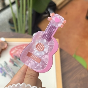 Pince à cheveux en forme de guitare rose marbré avec détail de cœur