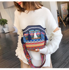 Close-up of ethnic woven bucket bag featuring colorful geometric patterns and blue tassels