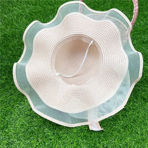 Détail de l'intérieur d'un chapeau de paille beige avec bord en tulle et mentonnière