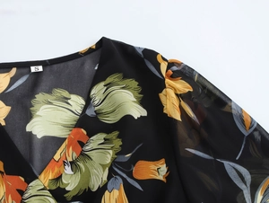 Dettaglio dello scollo a V e della stampa floreale su abito in chiffon nero con etichetta S
