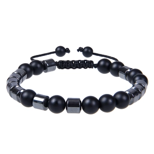 Detail van verstelbaar gevlochten koord en matzwarte stenen kralen op de armband