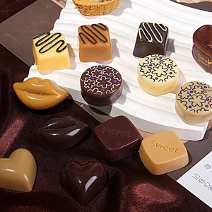 Chocolate style resin charms in heart and square shapes on a wavy white display stand