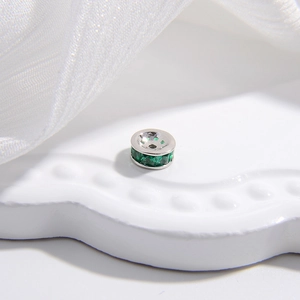 Dettaglio macro di charm in argento S925 con cristallo verde smeraldo per gioielli fai da te