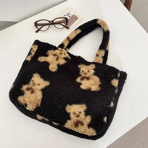 Detail shot of black faux shearling tote bag featuring a cute brown teddy bear plush pattern