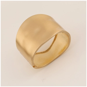 Detail of wide matte gold cuff bracelet featuring irregular geometric brushed metal texture