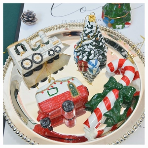 Close-up of glittery Christmas tree ornaments set on a reflective silver tray