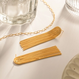 Detailed macro shot of elegant golden tassel chain earrings with smooth metallic finish