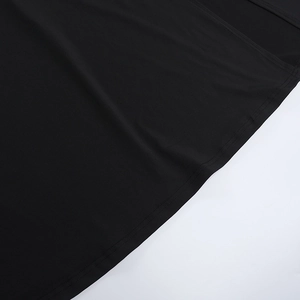 Détail de l'ourlet à double couture et texture du tissu sur une robe noire à col en V