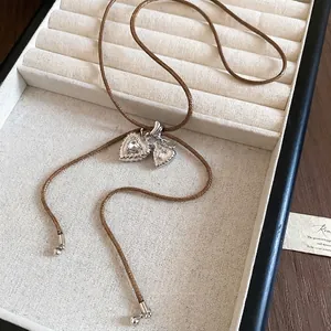 Elegant double heart pendant necklace with zircon crystals and brown woven cord