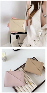 Detail of minimalist cream and pink bifold wallets with slant card slots and zip closure