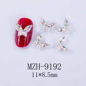Macro detail of silver alloy butterfly nail charm with AB crystals and white pearls