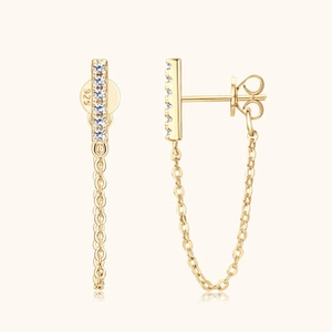 Macro detail of S925 sterling silver stamp on gold drop earrings with tassels