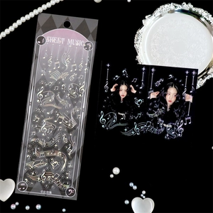 Macro view of holographic sheet music stickers with music notes and silver foil accents