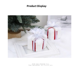 Detail showing two white plush Christmas gift box ornaments with red ribbon and white bows