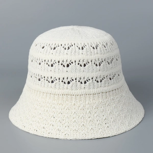 Detailed view of white hollow-out crochet knit pattern on a minimalist bucket hat