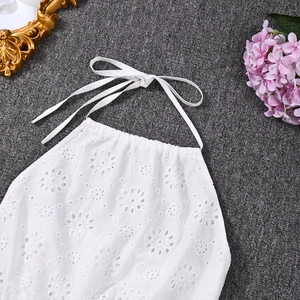 Detail view of white cotton halter top featuring intricate daisy eyelet embroidery