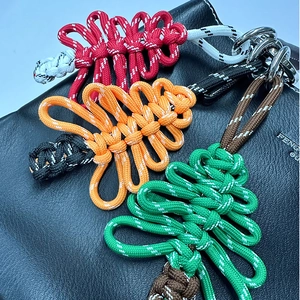 Pendentifs sapin de Noël tissés à la main en trois couleurs sur un sac en cuir noir