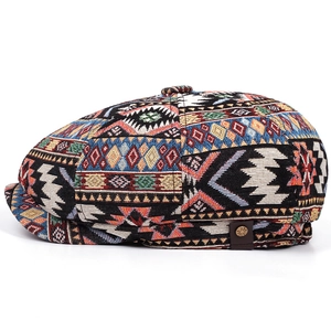 Detail of bohemian geometric knit fabric on the baker boy hat with leather patch and rivet