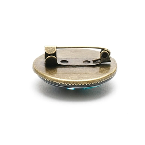 Retro Route 66 round brooch in bronze metal finish with blue crystal detail view